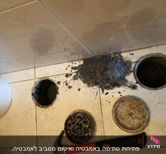 כלי עבודה וצינורות פתוחים על רצפת חדר אמבטיה
